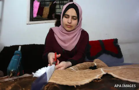 Palestinian student, Maram al-Haj Ahmed, 21, weaves carpets at her home, in Gaza city, on December 23, 2019. Al-Haj Ahmed a dental surgery student, where she works in this profession to help herself to complete her study...