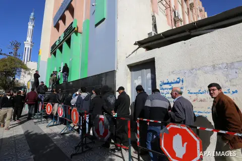 Palestinians wait to receive their financial aid outside the Post Office, in Gaza city, on December 24, 2019.The Qatar grant on Wednesday began disbursing $100 to Poor Families. Photo by Ashraf Amra