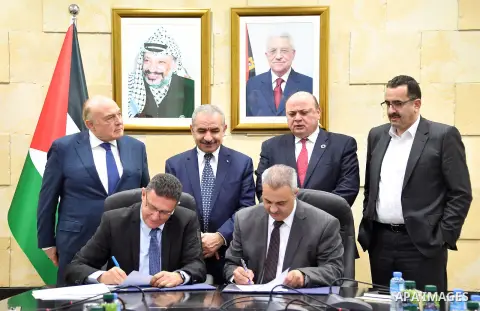 Palestinian Prime Minister Mohammad Ishtayeh, signs an agreement ending the Jerusalem electricity crisis, in the West Bank city of Ramallah, on December 29, 2019. Photo by Prime Minister Office