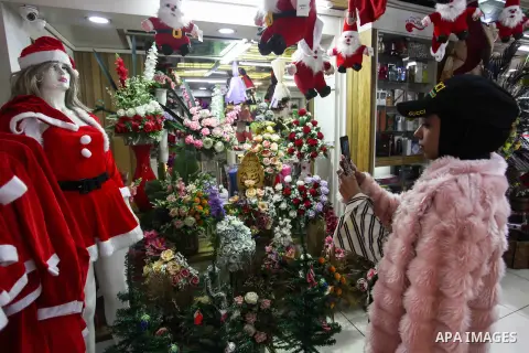 Palestinian vendors display flowers, red teddy bears, red ballons and pillows as part of Christmas and New Year festivities, in Gaza city, on December 31, 2019. Photo by Mahmoud Ajjour