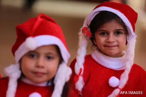 Palestinian children dressed as Santa Claus gestures during an exhibition of local traditional crafts, made by Palestinian women in Gaza City on December 31, 2019. Photo by Ashraf Amra