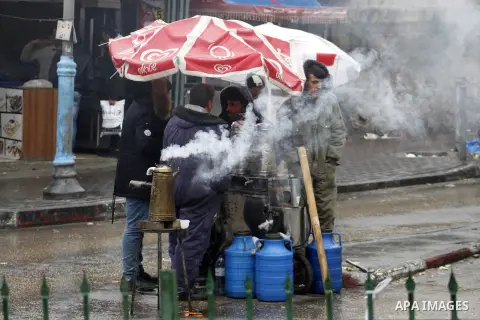 Palestinians walk in a street during a rainy day, in the West Bank city of Hebron, January 08, 2020. Photo by Mosab Shawer