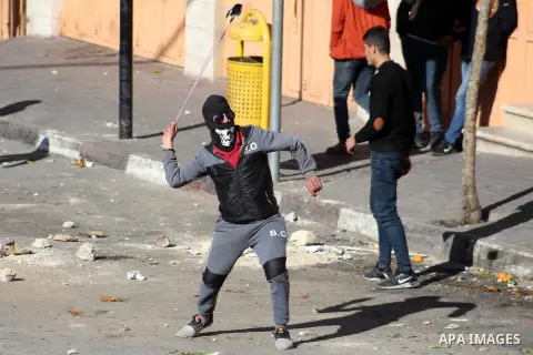 Palestinian protesters hurls a stones towards Israeli security forces during clashes with Palestinian protesters following a demonstration against US President Donald Trump's Century Deal "expected peace plan" in the Wes...
