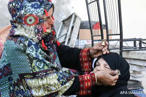 A Palestinian Hadia Qudaih 70, puts a traditional eye cosmetic "Arab kohl or Black eyeliner" in the eye of a woman at her home in Khan Younis in the southern of Gaza strip, on February 17, 2020. Eye liner or eyeliner is...