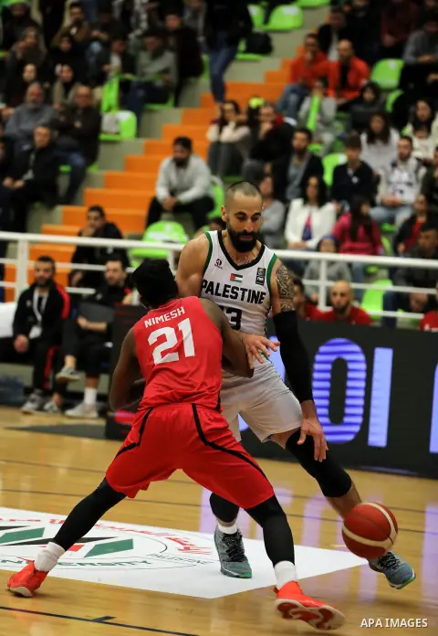 Palestinian basketball players (white T-shirt) and Sri Lanka basketball players (red T-shirt), compete during a 2021 FIBA World Cup Asian Qualifiers match, at the Arab American University stadium in the West Bank city of...