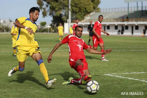 Palestinian football players of Khadamat Al-Maghazi (Red) and Al-Toffah (yellow) compete during match premier League in Alyarmuk stadium in Gaza City, in Gaza City on March 10, 2020. Photo by Mahmoud Ajjour
