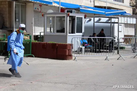 Palestinian workers disinfect gates and barriers near the near the Ibrahimi mosque in the Old city of the West Bank city of Hebron as a preventive measure amid fears of the spread of the novel coronavirus, on March 11, 2...