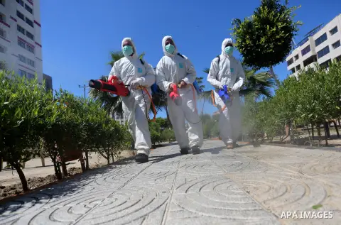 Palestinian workers disinfect the streets, as a preventive measure amid fears of the spread of the coronavirus, in Gaza City on March 22, 2020. Authorities in Gaza confirmed the first two cases of novel coronavirus, iden...