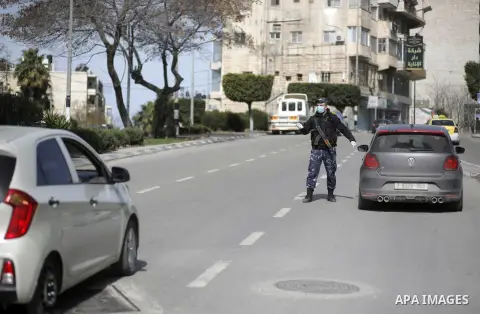 Palestinian policemen stand at the streets during of a "mandatory quarantine" that was announced by the Palestinian Authority as part of measures against the COVID-19 coronavirus pandemic, in the West Bank city of Nablus...