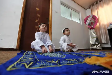 Palestinian preacher Mustafa al-Qishawi, 34, prays with his children on Friday prayers at his home after mosques have been closed as a precaution against the spread of the coronavirus disease (COVID-19), in Gaza City on...