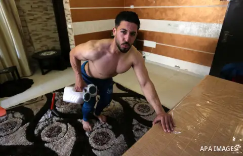 Palestinian fitness trainer and bodybuilding, Ahmed al-Sawi uses alternative tools as he trains at his home as a preventive measure amid fears of the spread of the novel coronavirus disease (COVID-19) in Gaza City on Apr...
