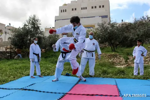 Palestinian national heroine Beesan al-Jubeh - under10-, trains with her family members, all wearing face masks and gloves due to the COVID-19 coronavirus pandemic, outside their house in the West Bank City of Hebron on...