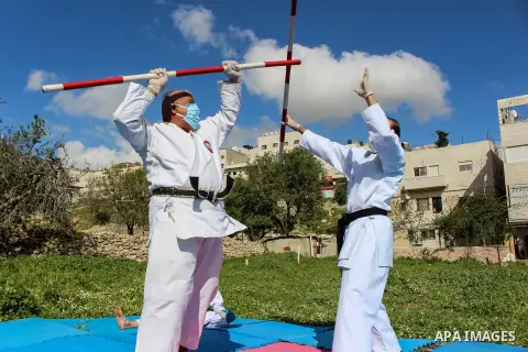 Palestinian national heroine Beesan al-Jubeh - under10-, trains with her family members, all wearing face masks and gloves due to the COVID-19 coronavirus pandemic, outside their house in the West Bank City of Hebron on...