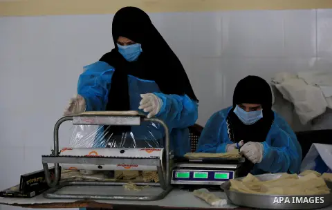 Palestinian women wear protective, make samosa and Kubba, to receive the Islamic holy month of Ramadan , as precaution against the coronavirus disease (COVID-19), in Khan Younith in the southern Gaza Strip on April 18, 2...