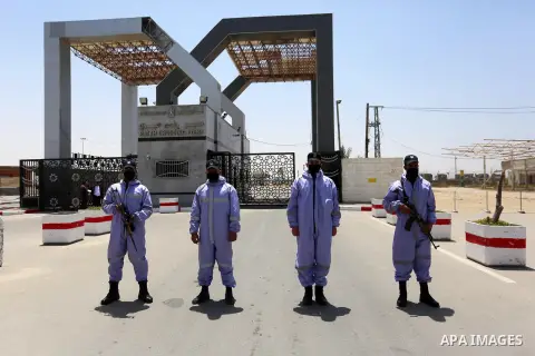 Members of Palestinian security forces wear protective gear as precaution against the coronavirus disease (COVID-19), stand guard at Rafah border crossing with Egypt in the southern Gaza Strip on May 12, 2020. Photo by A...