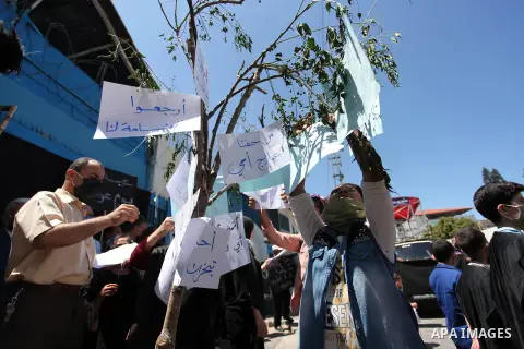 Children of Palestinians formerly employed by United Nations Relief and Works Agency (UNRWA) some wearing masks as a precaution against the spread of the coronavirus disease (COVID-19) take part in a protest demanding th...