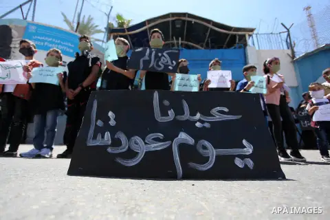 Children of Palestinians formerly employed by United Nations Relief and Works Agency (UNRWA) some wearing masks as a precaution against the spread of the coronavirus disease (COVID-19) take part in a protest demanding th...