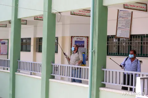 Palestinian workers disinfect a school, for the final high school exams, known as "Tawjihi", as a preventive measure amid fears of the spread of the novel coronavirus, in Nuseirat in the center of Gaza Strip on May 28, 2...