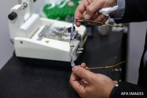 Palestinian optometrist Hisham Al-Tabbaa, 37, displays "blue cut lens" at his center, in Gaza City on June 2, 2020. Blue cut lens is a new technology which reduces exposure to blue rays, block UV rays, and increase of Me...