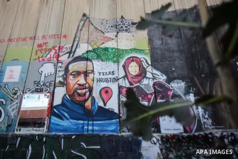 A picture shows depicts George Floyd, a black American who died after a white policeman knelt on his neck during an arrest in the US, at the Israeli separation wall in the West Bank city of Bethlehem on June 9, 2020. Pho...