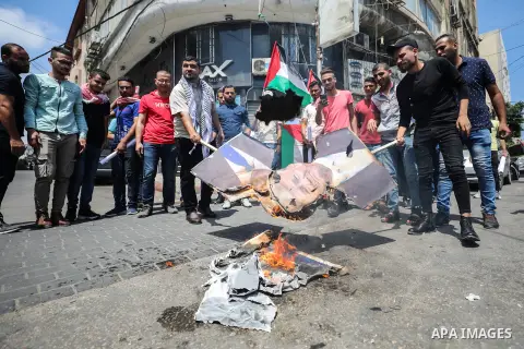 Palestinian protesters burn posters depicting the faces of US President Donald Trump and Israeli Prime Minister Benjamin Netantyahu during a protest against Israel's plans to annex parts of the occupied West Bank, in Gaz...
