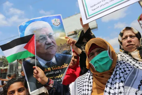 Palestinian women hold placards and national flags during a demonstration against Israel's West Bank annexation plans in front of the gate of Erez crossing with Israel in Beit Hanoun in the northern Gaza Strip, on July 6...