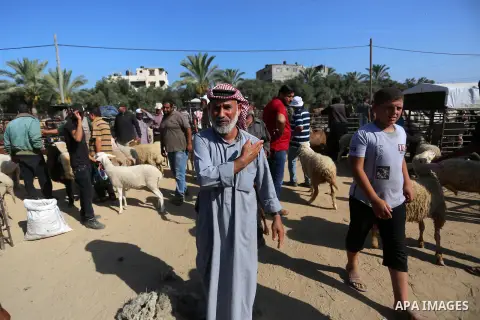 Palestinians gather at a live stock market, ahead of Eid al-Adha in Deir al-Balah, in the center of the Gaza Strip on July 8, 2020. As the low turnout on the buy sheep due to the deteriorating economic situation. Photo b...