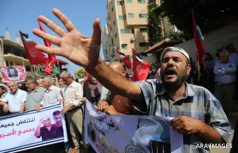 Palestinians take part in a protest in solidarity with prisoners in Israeli jails, in front of the Red cross office, in Gaza city on July 20, 2020. Photo by Ashraf Amra