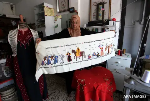 A Palestinian woman sews a traditional heritage embroidery at a workshop, on the traditional Palestinian Costume Day, in Gaza ciry, on July 25, 2020. Palestinian National Costume Day is an event organized by a group of y...