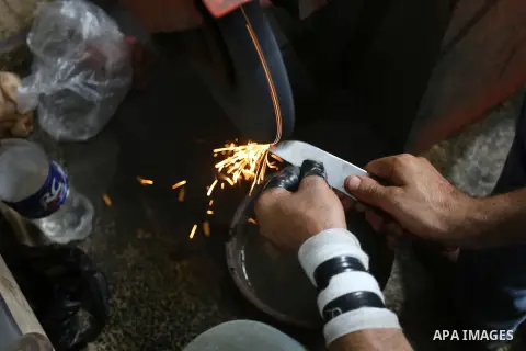 A Palestinian worker sharps knives at a workshop ahead of Eid al-Adha in Gaza city on July 27, 2020. The knives use to slaughter cattle and sheep for the Muslim holiday of Eid al-Adha or the Feast of Sacrifice, which mar...