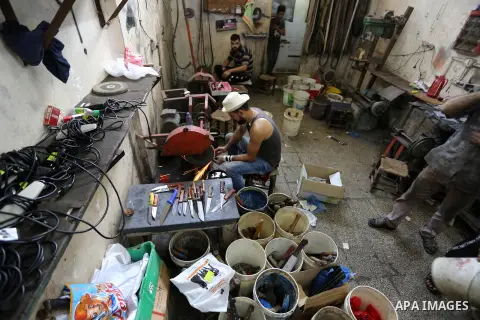 A Palestinian worker sharps knives at a workshop ahead of Eid al-Adha in Gaza city on July 27, 2020. The knives use to slaughter cattle and sheep for the Muslim holiday of Eid al-Adha or the Feast of Sacrifice, which mar...