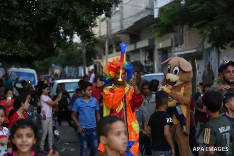 Palestinian clowns play with the children ahead of Eid al-Adha festival in Khan Yunis in the southern Gaza Strip, on July 30, 2020. Muslims across the world are preparing for Eid al-Adha holiday when custom requires the...