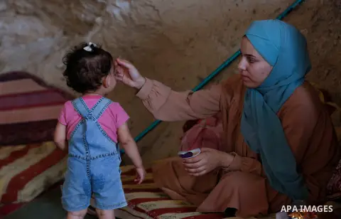 Palestinian wife Ahmed Amarneh feeds her daughter Maria, in her husband's house, which he built in cave, in the village of Farasin, west of Jenin, in the northern West Bank on August 11, 2020. Amarneh, a 30 year old civi...