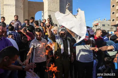 Palestinians carry pictures of Palestinian President Mahmoud Abbas during a protest against the United Arab Emirates' deal with Israel to normalise relations, in Rafah in the southern of Gaza Strip, on August 20, 2020. P...
