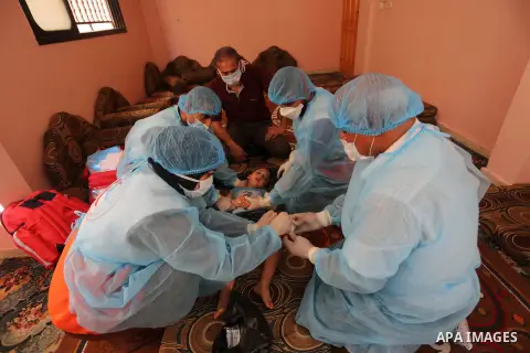 Palestinian nurses from the Palestinian Red Crescent Society wearing protective gear, provide medical services to patients in their homes in Dair Al Balah in the central of Gaza Strip, on August 30, 2020, during a lockdo...