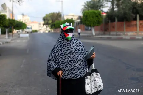 A Palestinian woman wears face mask, walks at a street during the imposed lockdown to mitigate virus outbreak in Gaza city, on Sept. 01, 2020. Photo by Mahmoud Ajjour