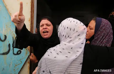 Palestinians mourn during the funeral of three children who were killed in a fire ignited by a candle used to light up their room during a power cut in al-Nusirat refugee camp in the central Gaza Strip on September 2, 20...