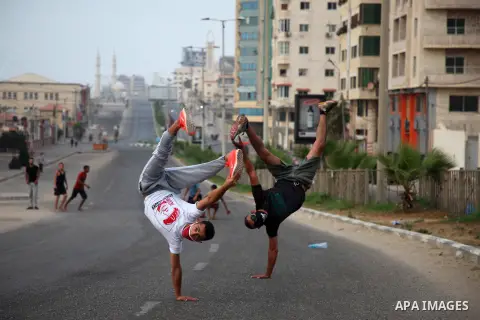 Palestinian Parkour players wear face masks show off their skills on a nearly deserted street during the imposed lockdown to mitigate virus outbreak in the Gaza Strip, in Gaza city on September 4, 2020. Photo by Mahmoud...