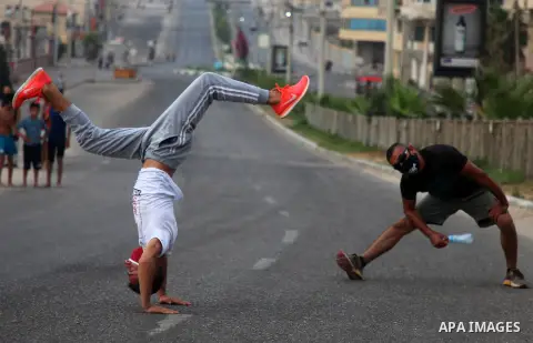 Palestinian Parkour players wear face masks show off their skills on a nearly deserted street during the imposed lockdown to mitigate virus outbreak in the Gaza Strip, in Gaza city on September 4, 2020. Photo by Mahmoud...