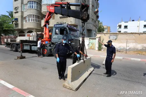 Palestinian policemen close a road with concrete barriers during a lockdown following the outbreak of the coronavirus disease (COVID-19), in Dair Al Balah in the central of Gaza Strip, on September 5, 2020. Photo by Ashr...