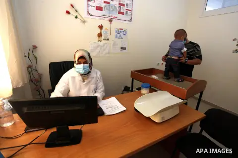 UNRWA employees wear face masks as they provide services for children in a clinic in Bureij refugee camp central of Gaza Strip on September 9, 2020. Photo by Mahmoud Ajjour