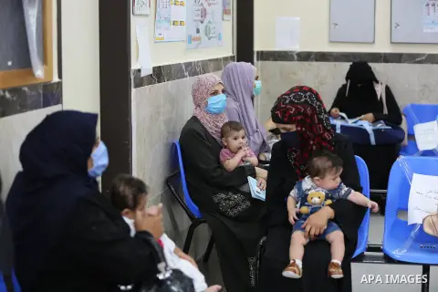 Palestinian women mask-clad due to the Covid-19 coronavirus pandemic wait with their children in a UN clinic to take Polio vaccine and Rota virus vaccines, in Deir Al-Balah, in the center of the Gaza Strip, on Sept. 12,...