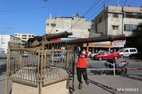 A Palestinian boy plays on the old British war cannon, in Dair Balah in the center of Gaza strip, on September 14, 2020. The cannon was extracted from a British warship that sank off the coast of Deir al-Balah in World W...