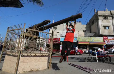 A Palestinian boy plays on the old British war cannon, in Dair Balah in the center of Gaza strip, on September 14, 2020. The cannon was extracted from a British warship that sank off the coast of Deir al-Balah in World W...