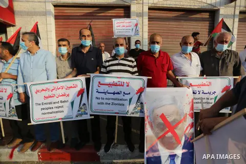 Palestinian protesters wearing protective masks, during a protest against the United Arab Emirates' and Bahrain's decisions to normalise relations with Israel, in Nuseirat in the central of Gaza Strip on September 15, 20...