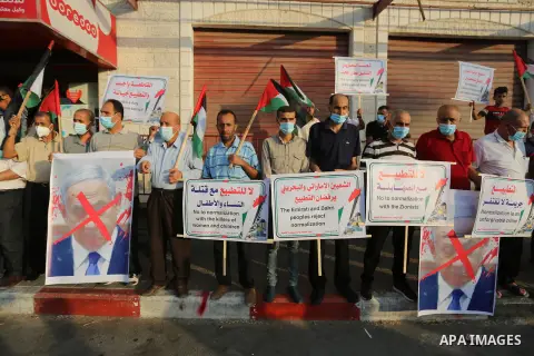 Palestinian protesters wearing protective masks, during a protest against the United Arab Emirates' and Bahrain's decisions to normalise relations with Israel, in Nuseirat in the central of Gaza Strip on September 15, 20...
