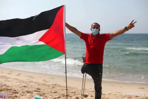Palestinians paint on the sand sculpture titled "normalization is betrayal", at the beach of Gaza city, on September 16, 2020. The decision by the UAE and Bahrain to normalise ties with Israel breaks with decades of cons...