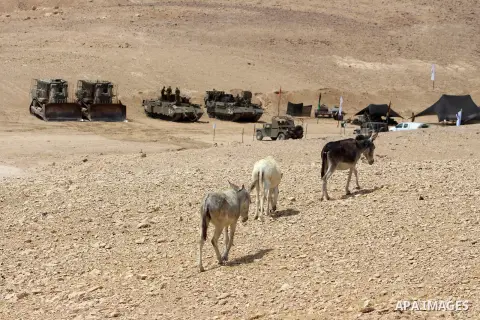 Israeli soldiers walk between their tanks during a military training, in Yatta village in the southern West bank district of Hebron on September 16, 2020. Photo by Mosab Shawer