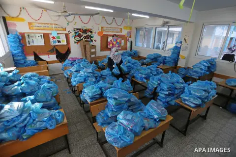 Palestinian students wearing protective masks, as they receive textbooks one of the United Nations Relief and Works Agency (UNRWA) schools, amid the coronavirus disease (COVID-19), at their school in Dair Al Balah in the...