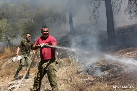 Palestinian members of Civil defense firefighters effort to control a fire that broke out Wadi al-Qaf Nature Reserve in the West Bank of Hebron, on October 24, 2020. Photo by Mashhor Wahwah/Wafa